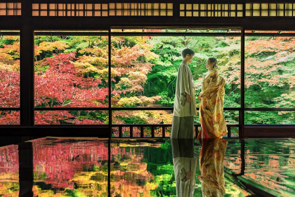 伝統的な瑠璃光院で、向かい合って微笑んでいる和装の新郎新婦